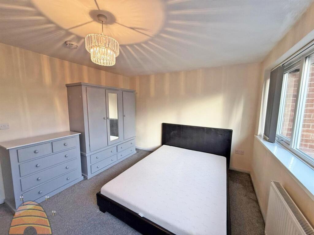 A spacious and well-lit double bedroom with mod...