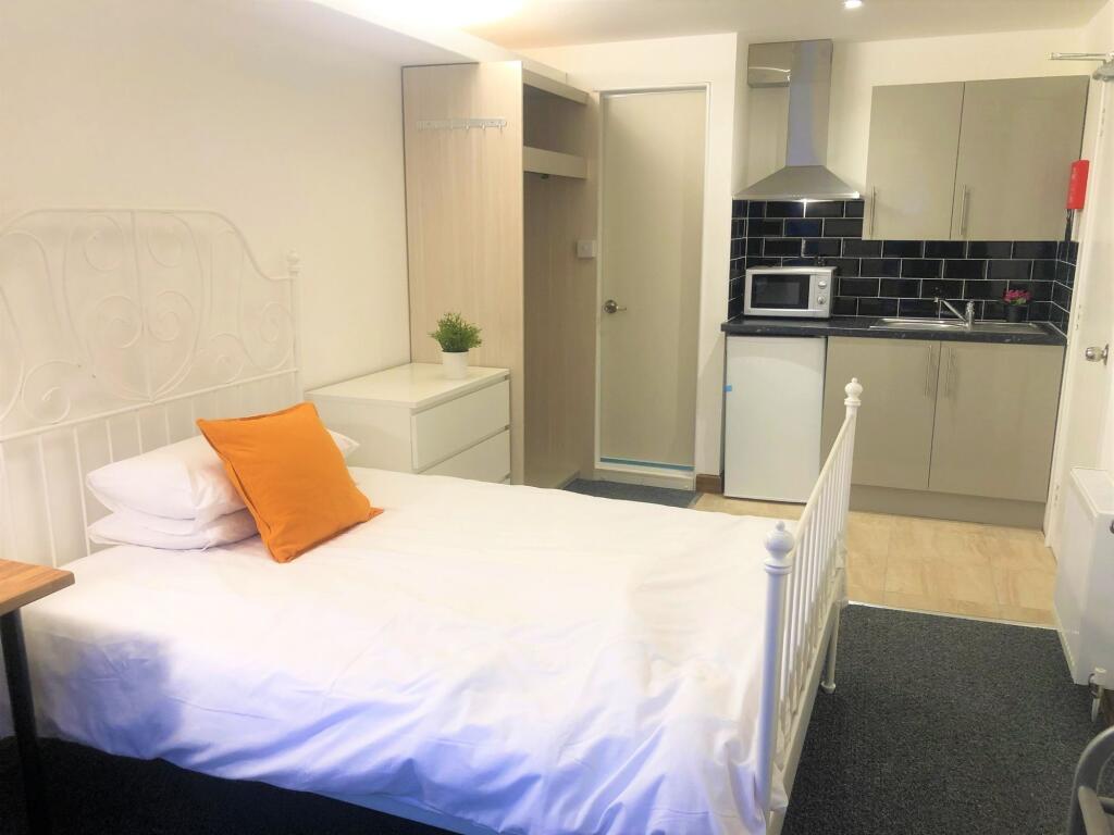 Bright and clean single bedroom with a white me...