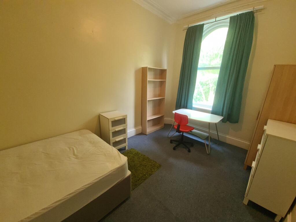 A cozy student bedroom featuring a single bed, ...