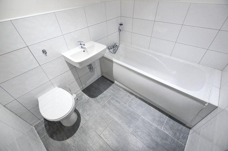 Bright and clean bathroom suite featuring a ful...
