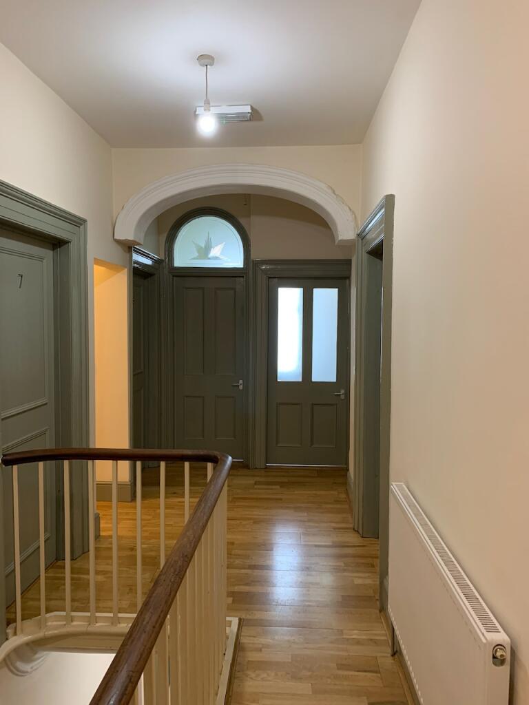 Bright and clean hallway with polished wooden f...