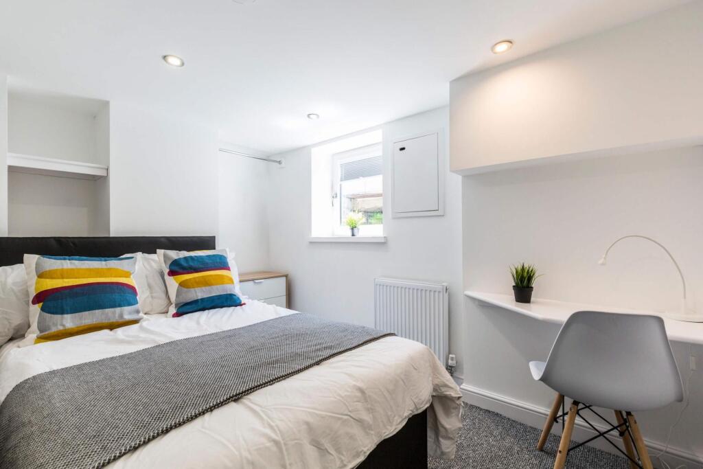A spacious and well-lit master bedroom featurin...