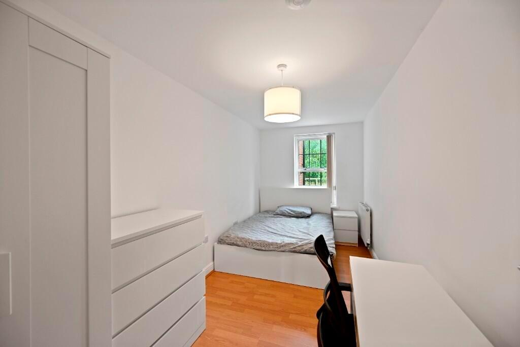 A clean, well-organized single bedroom with a c...