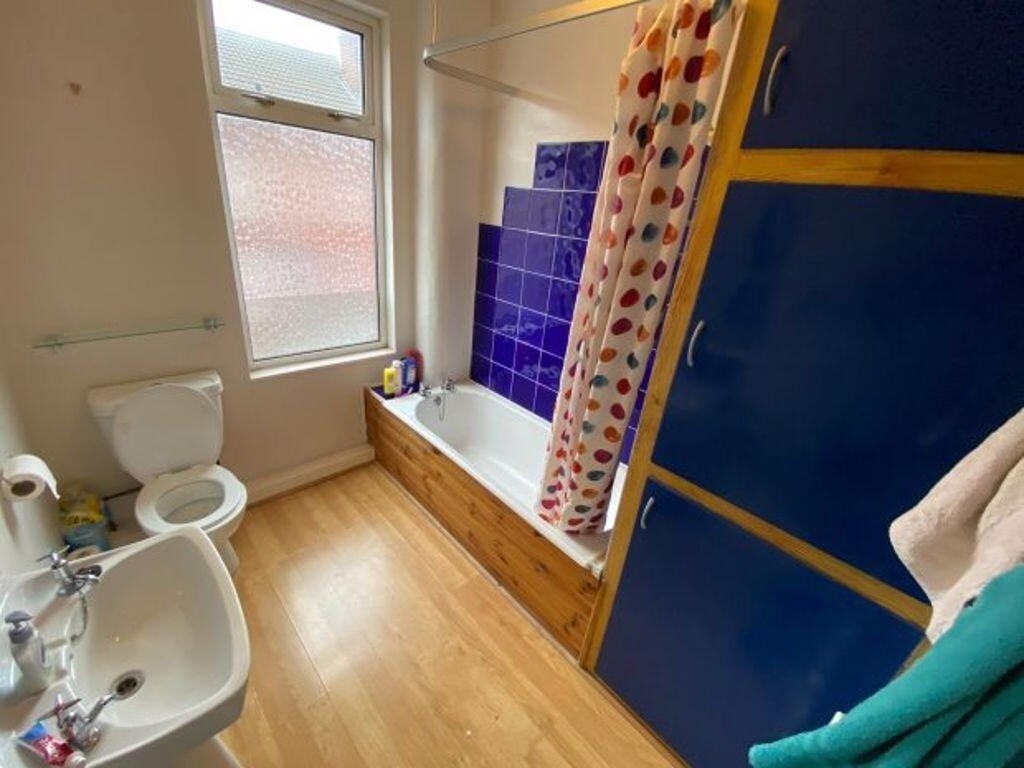 Bright bathroom with a white sink and toilet, t...