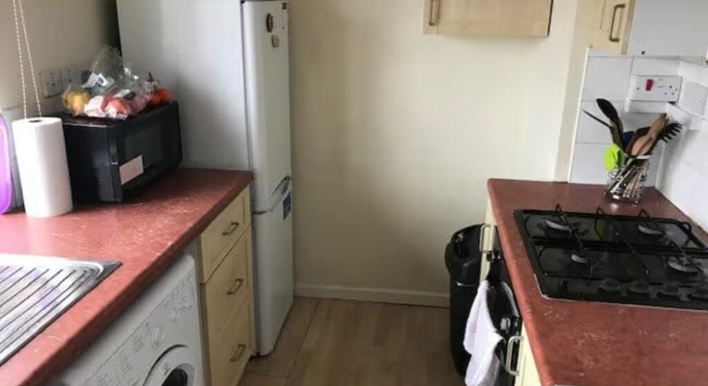 Compact kitchen featuring essential appliances ...