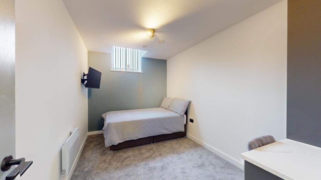 A spacious and tidy double bedroom featuring a ...