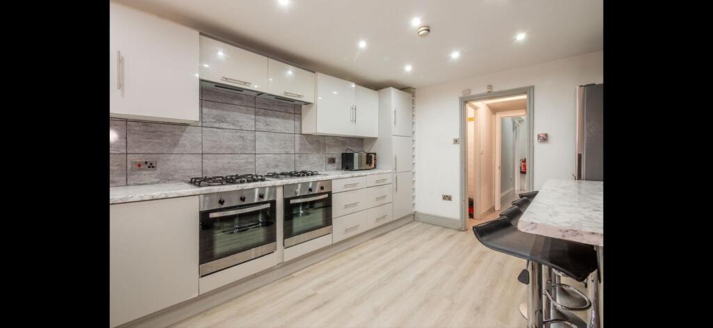 Bright modern galley kitchen with integrated ap...