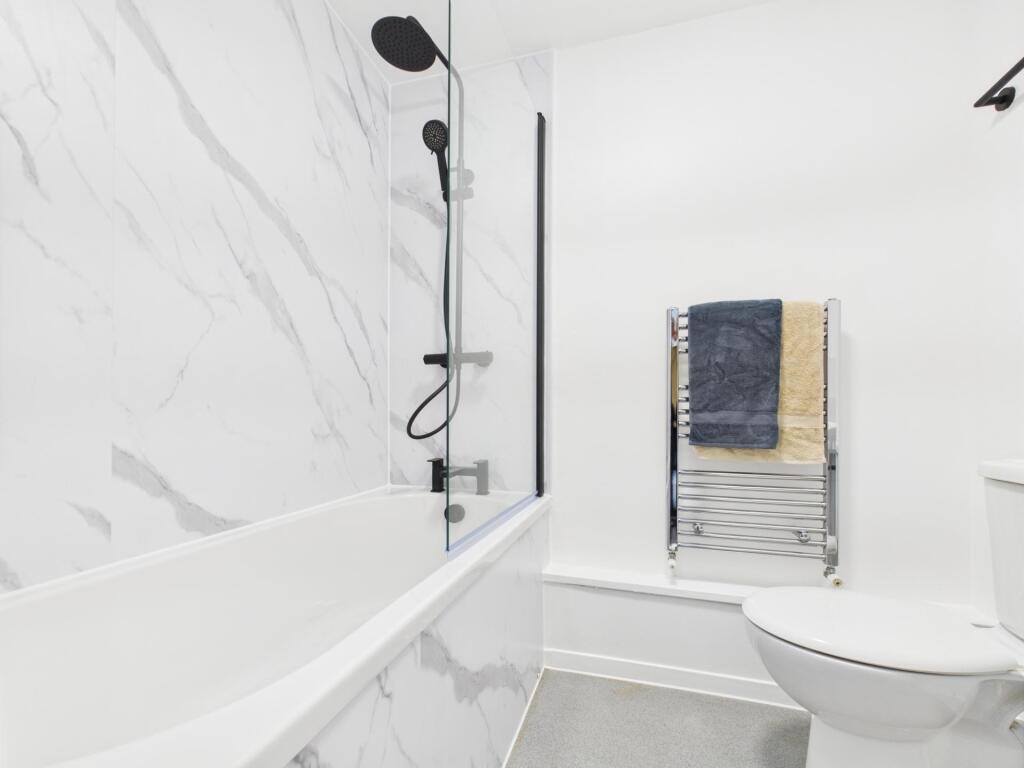 Bright modern bathroom with marble-effect wall ...
