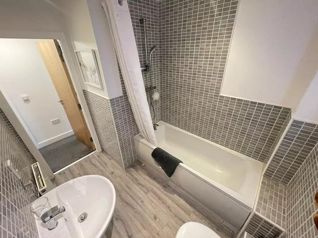 This stylish bathroom suite features modern til...