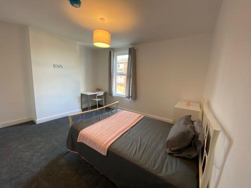 A neat and cozy single bedroom featuring a comf...