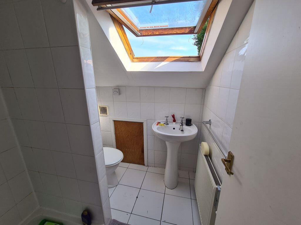 Bright bathroom with white tiled walls and floo...