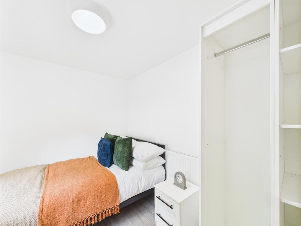 Bright, simply furnished bedroom with a neatly ...