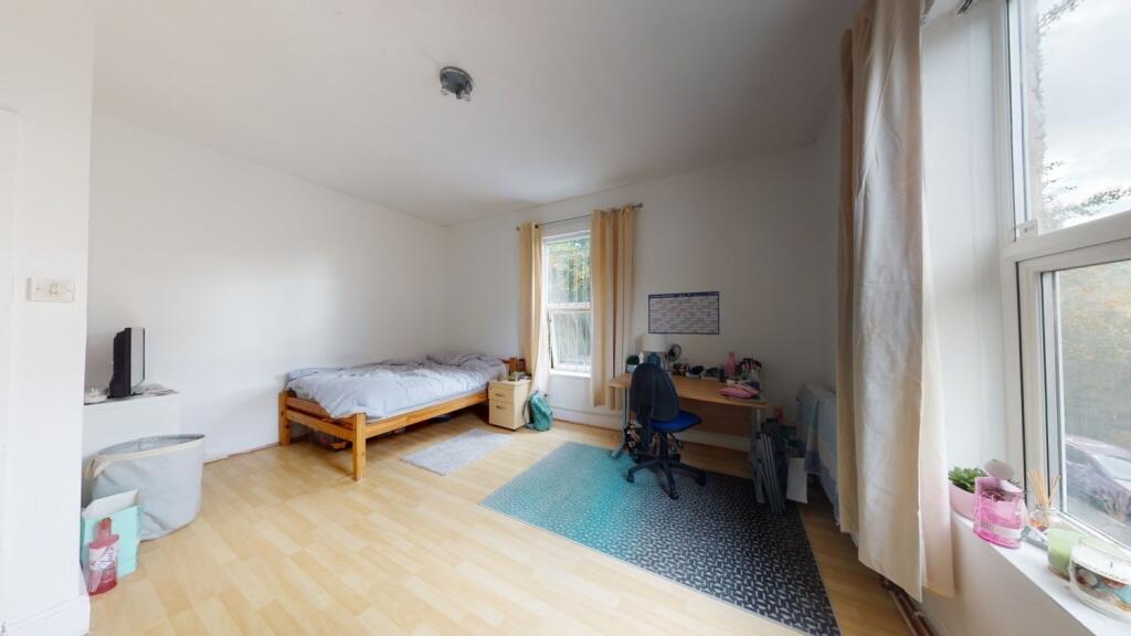 A bright and tidy single bedroom featuring a co...