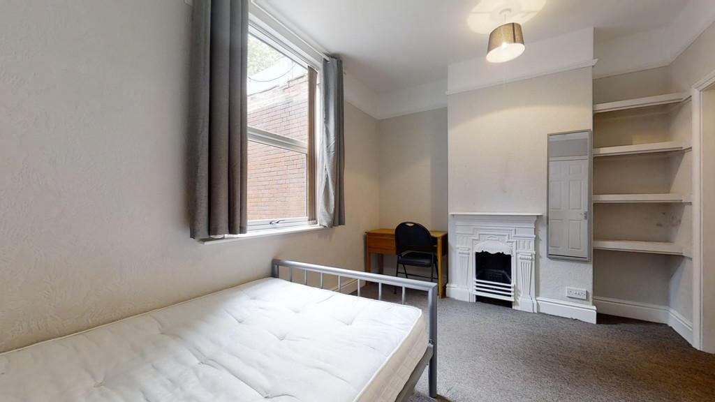 A cozy single bedroom featuring a single metal-...