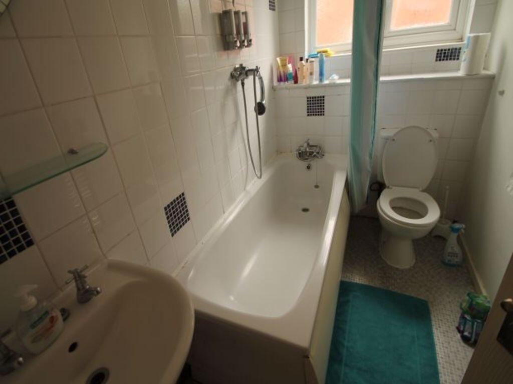 Bright bathroom with a full-size bathtub, showe...