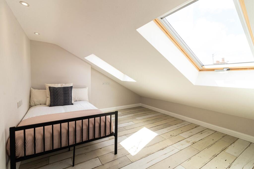 A bright and inviting bedroom featuring a cozy ...