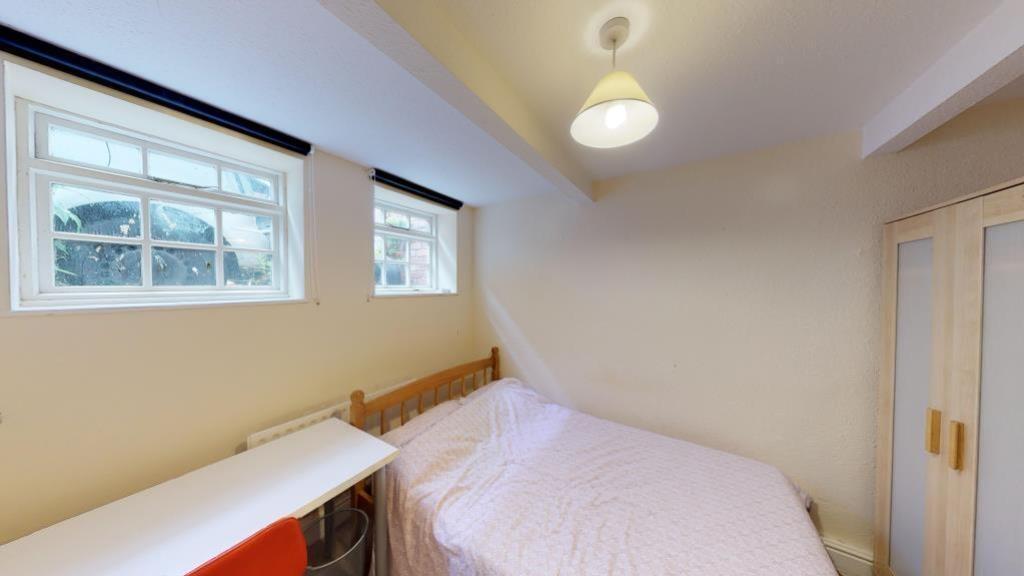 A neat and simple bedroom featuring a comfortab...