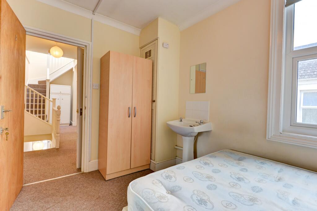 A compact and clean single bedroom with a wardr...