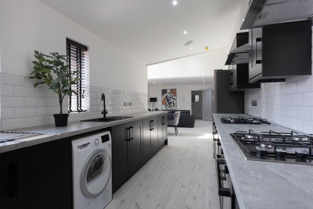 A modern kitchen featuring sleek black cabinetr...