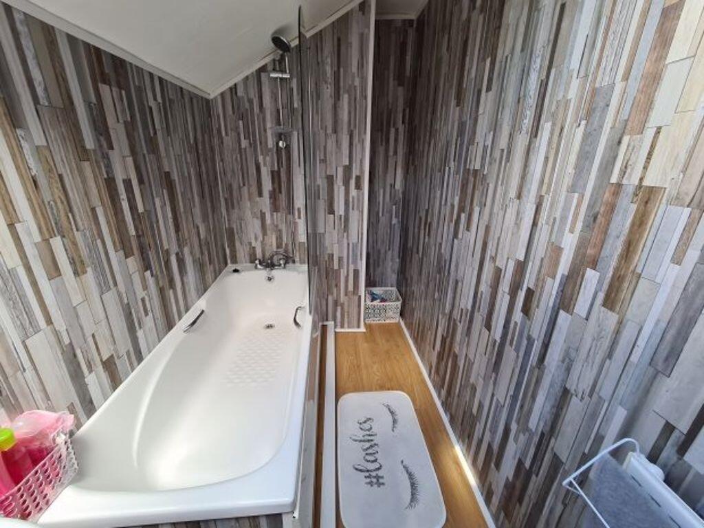 A modern bathroom featuring a spacious bathtub ...