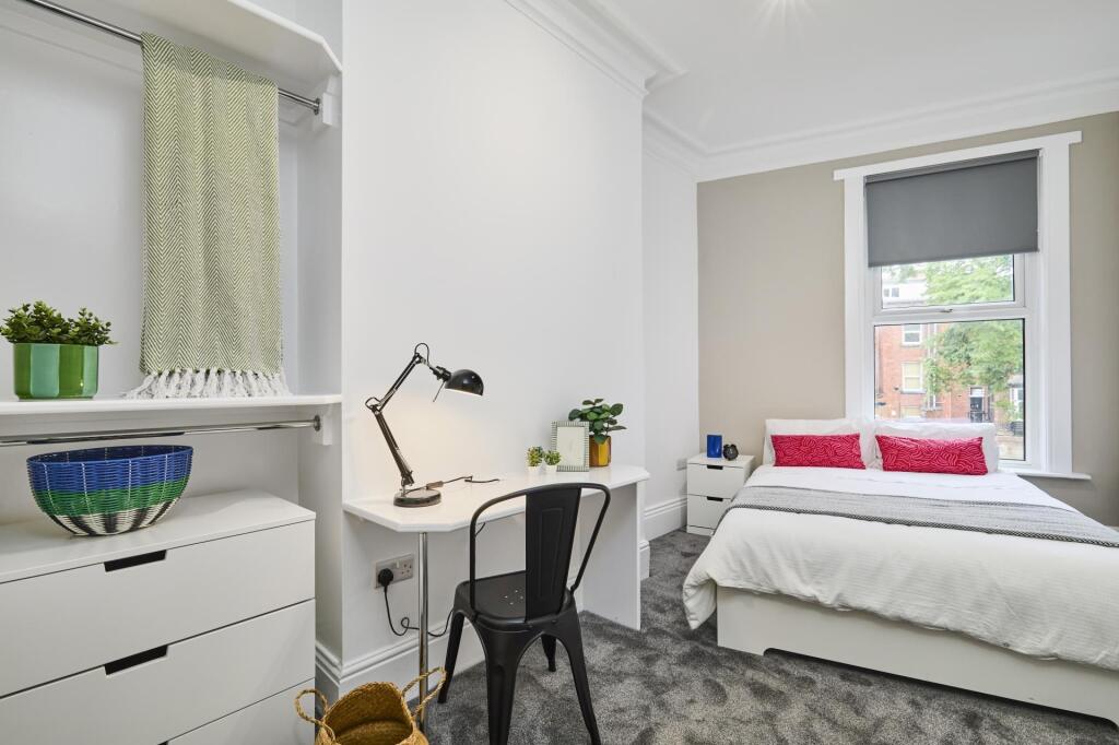 A bright and inviting student bedroom featuring...