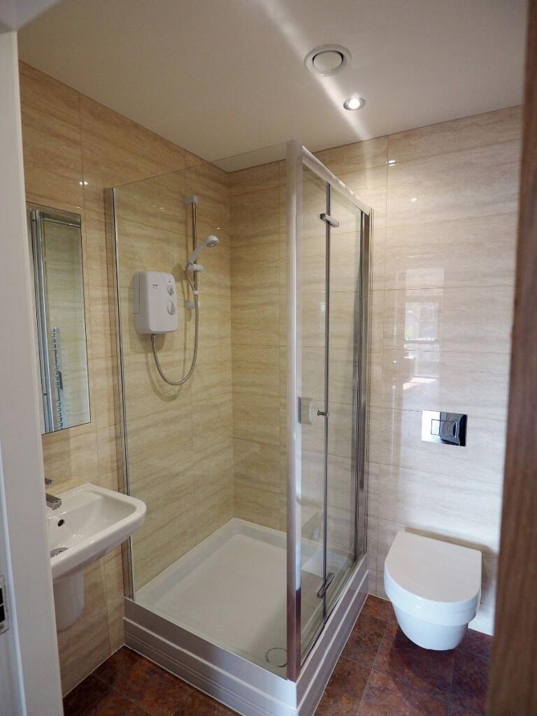 A modern bathroom featuring a glass shower encl...