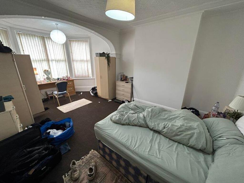 A spacious double bedroom with ample natural li...