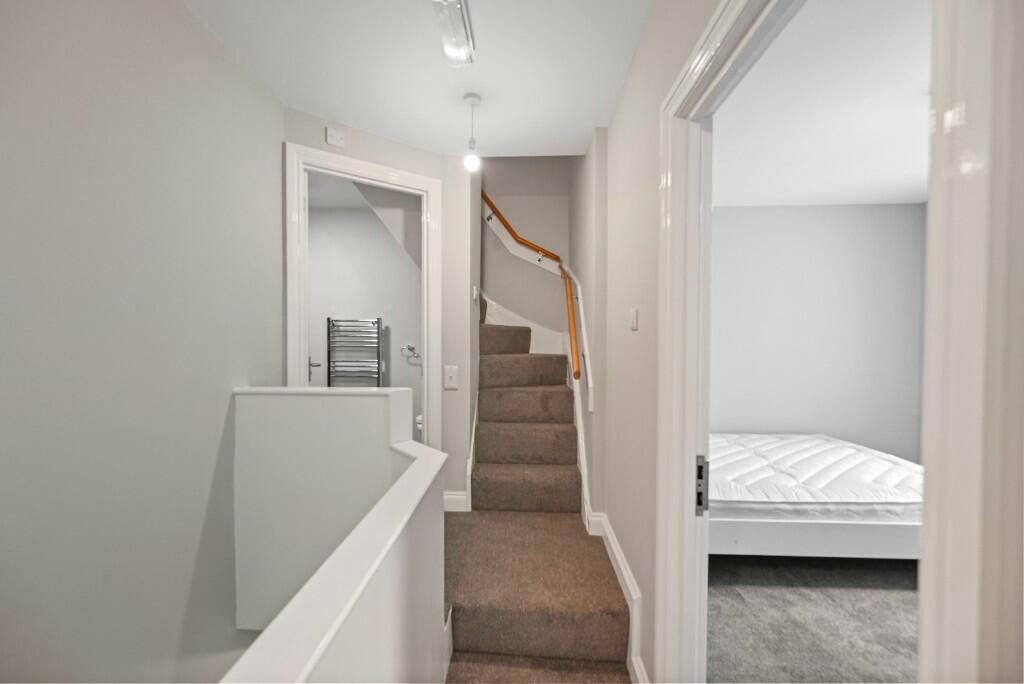 Bright and clean hallway with neutral decor, ca...