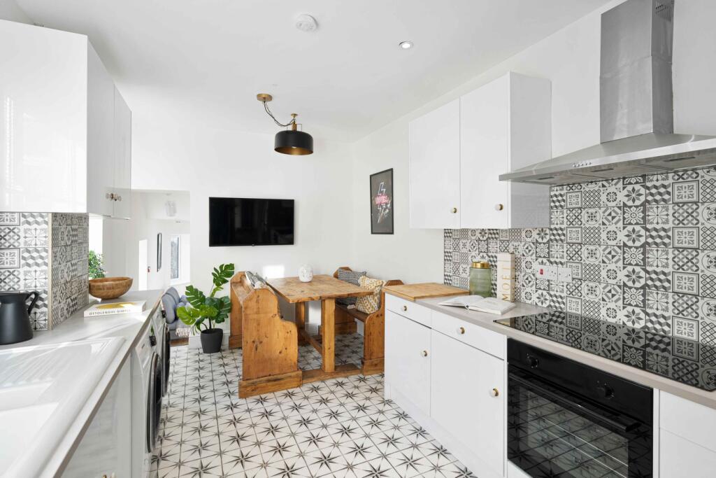 A bright and stylish kitchen featuring modern a...