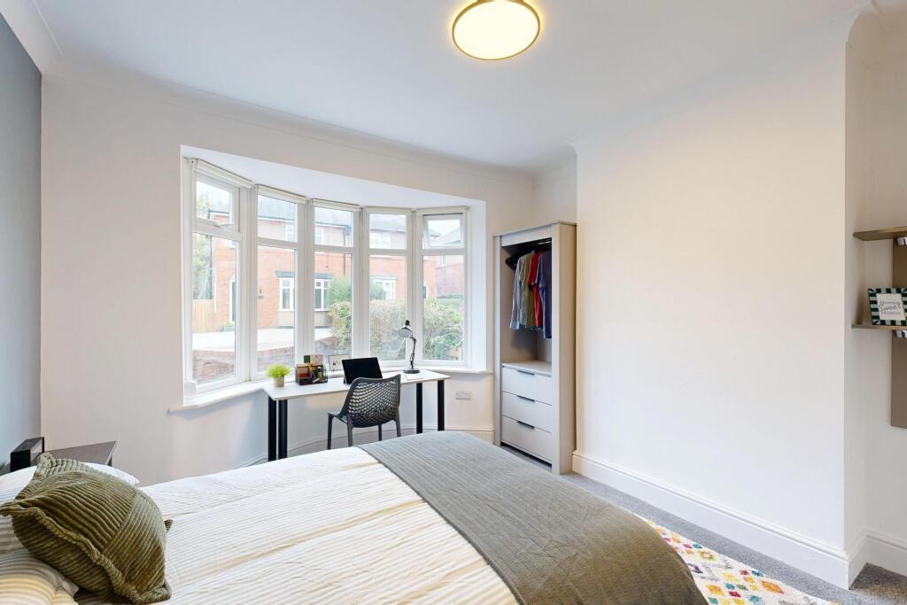 A bright and spacious master bedroom with a lar...