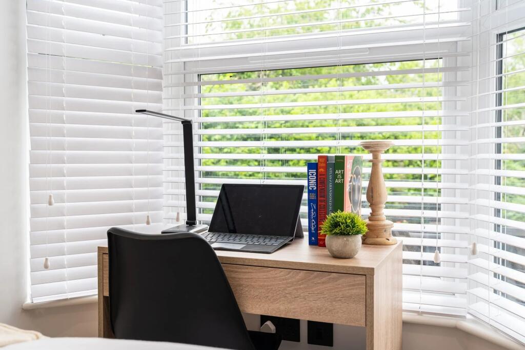 Bright bay-window workspace with a compact wood...