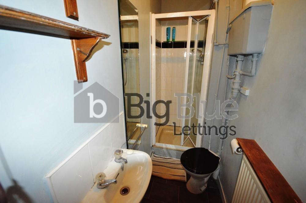 Compact bathroom featuring a shower enclosure, ...