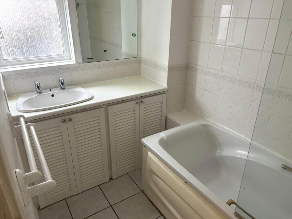 Bright, well-kept bathroom with a vanity sink, ...