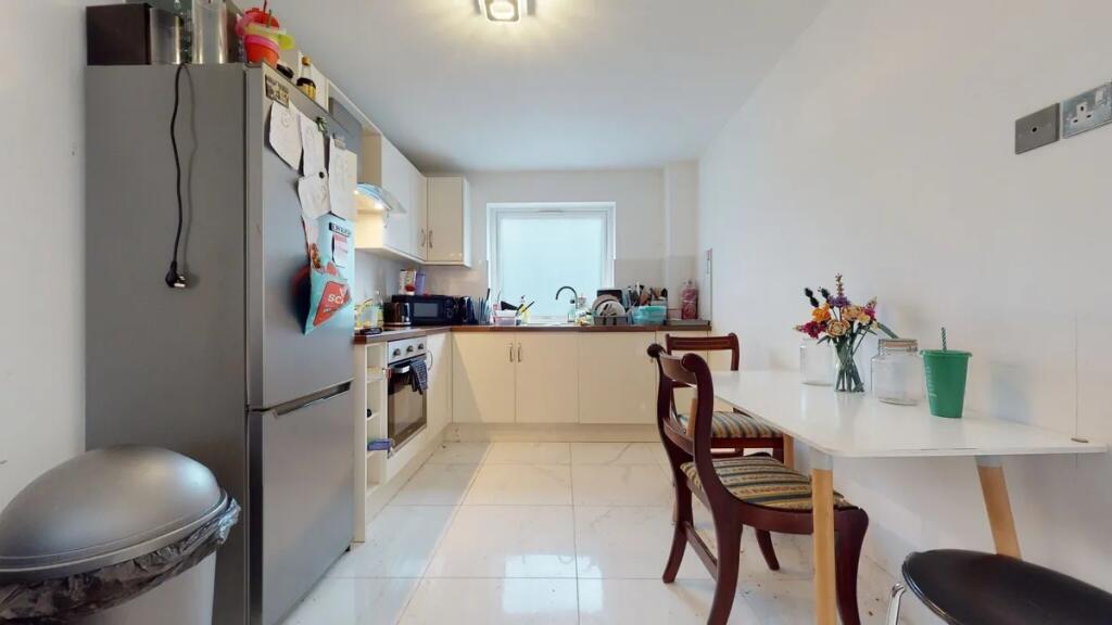 Bright and tidy kitchen featuring modern applia...
