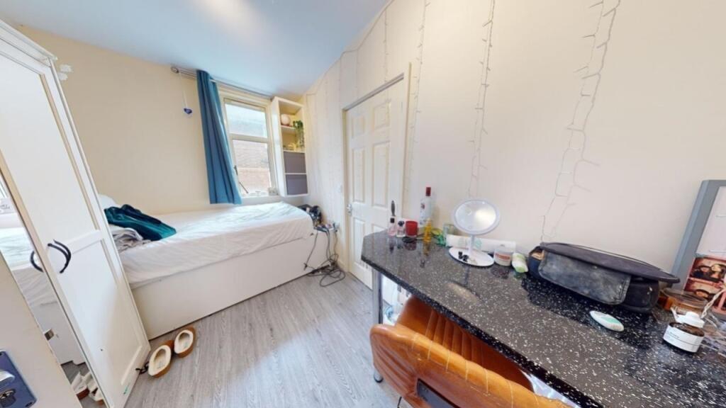 A bright and cozy single bedroom featuring a co...