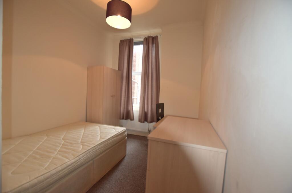 A bright and tidy double bedroom featuring a fi...