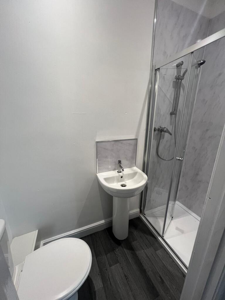 A modern bathroom featuring a sleek white pedes...