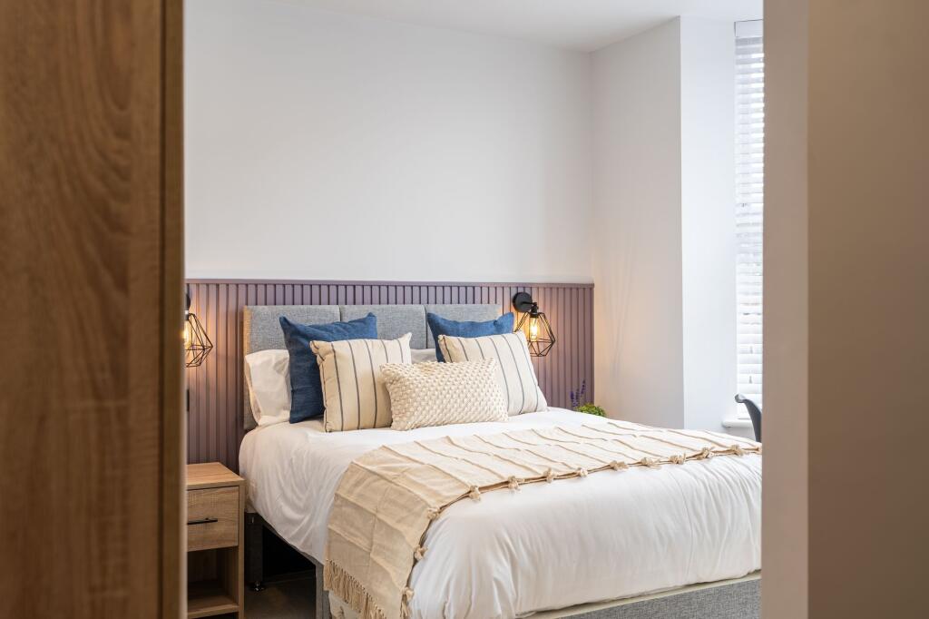 A spacious, elegantly decorated bedroom featuri...