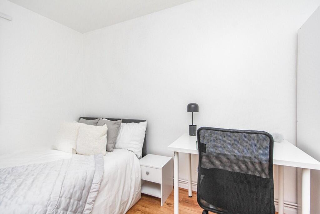 A bright and tidy single bedroom featuring a co...