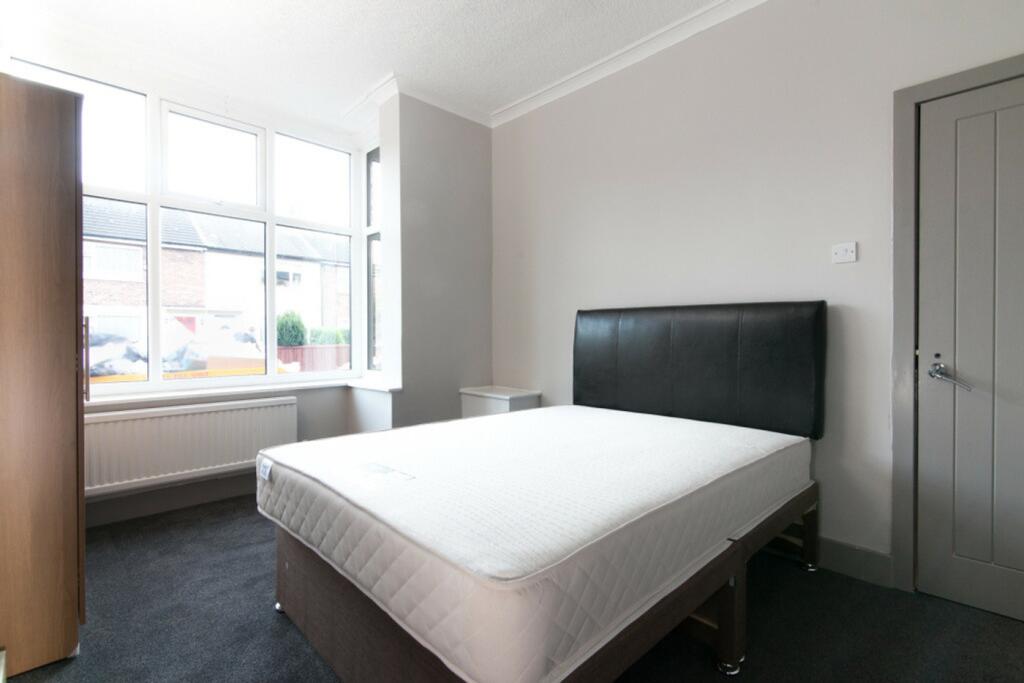 A bright and spacious double bedroom featuring ...