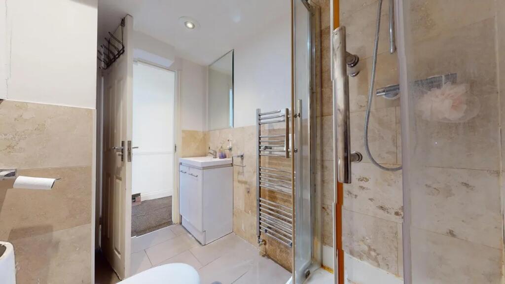 A modern bathroom featuring a clear glass showe...