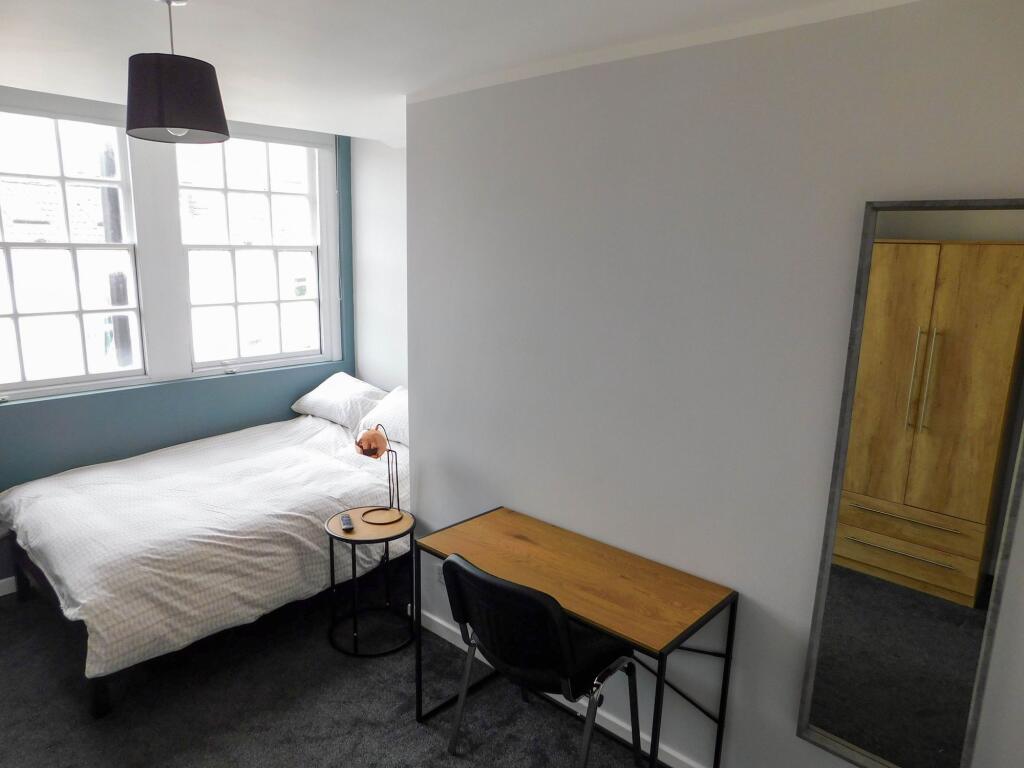 A bright and inviting bedroom with a comfortabl...