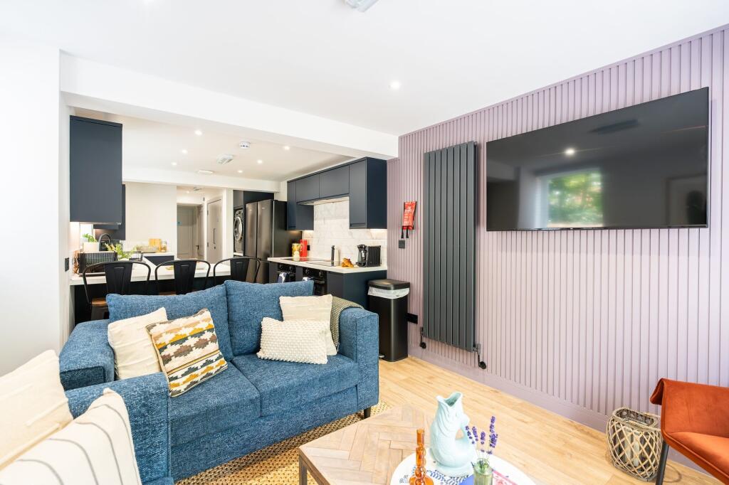 Bright and modern living room featuring a spaci...