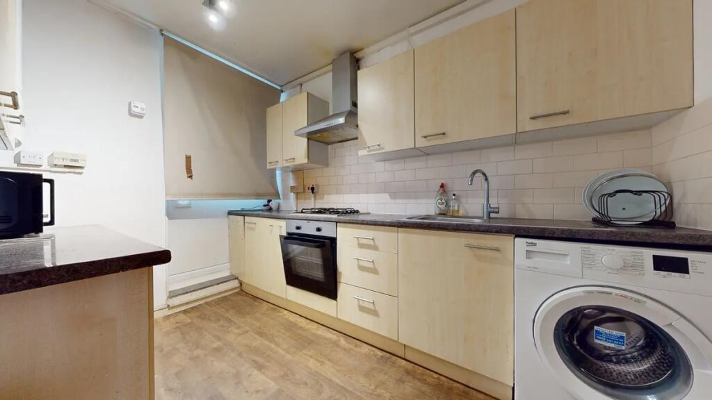 A modern kitchen featuring light wood cabinetry...