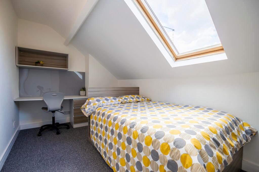 Bright and cozy single bedroom featuring a comf...