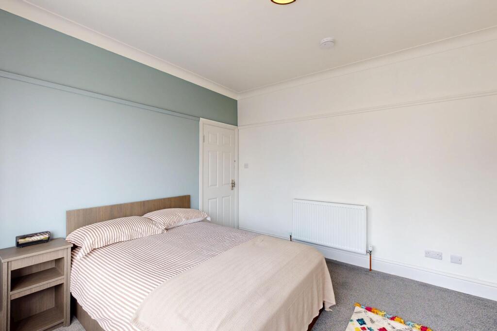 A bright and welcoming bedroom featuring a doub...