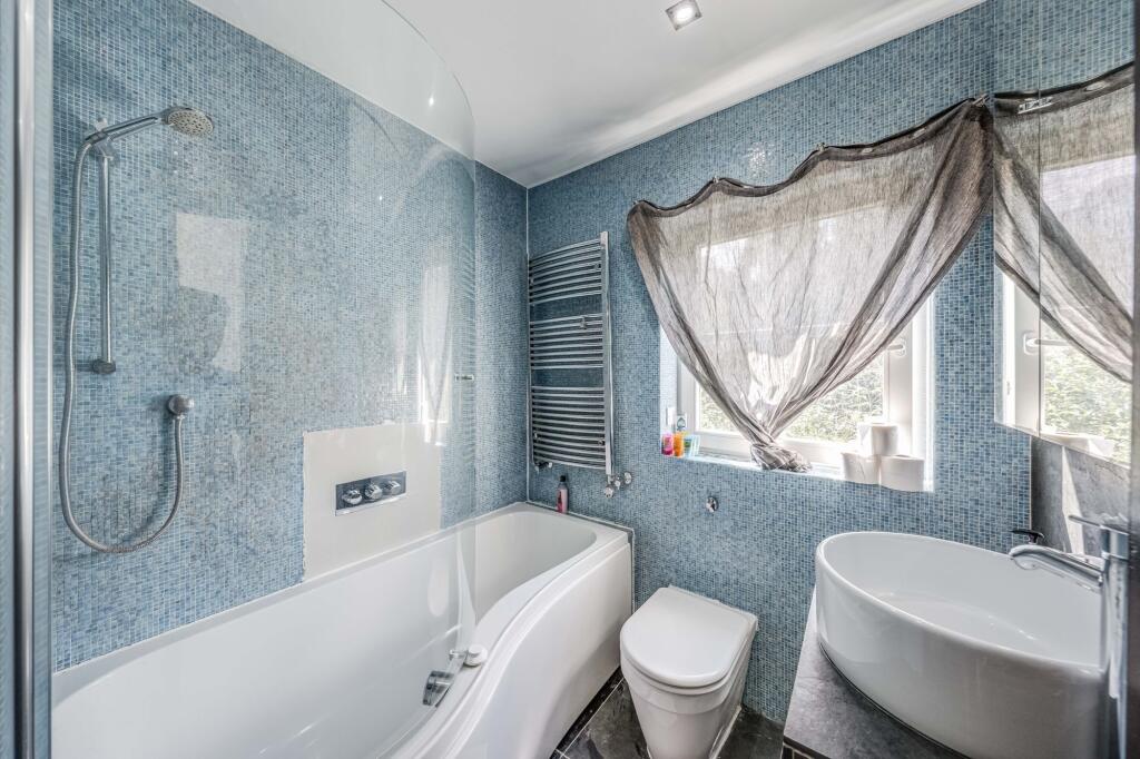 Bright and modern bathroom suite featuring a st...