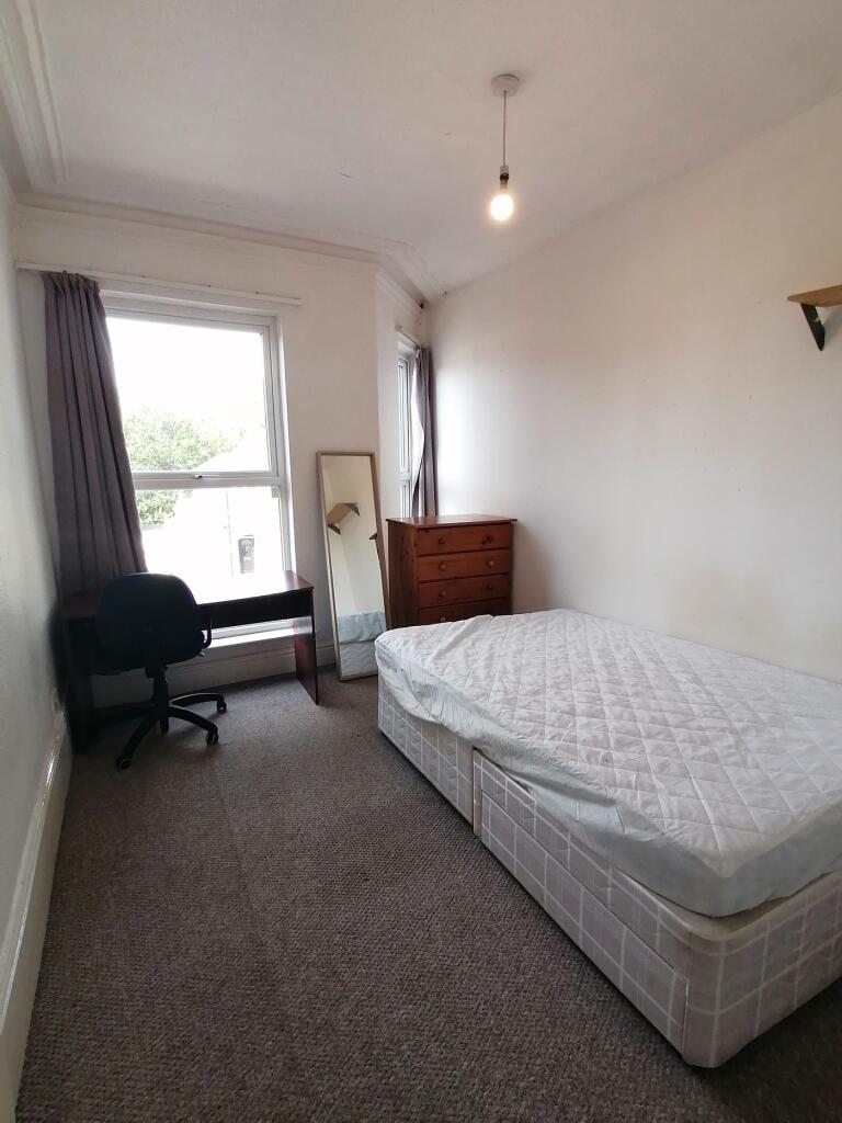 A bright and spacious double bedroom with a com...