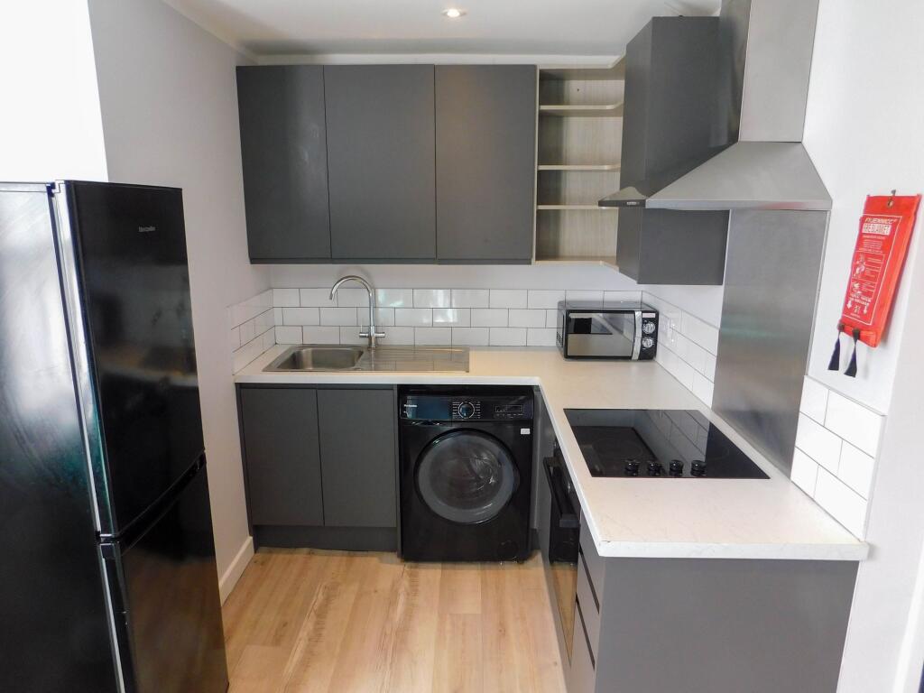 Modern kitchen with sleek gray cabinetry, white...