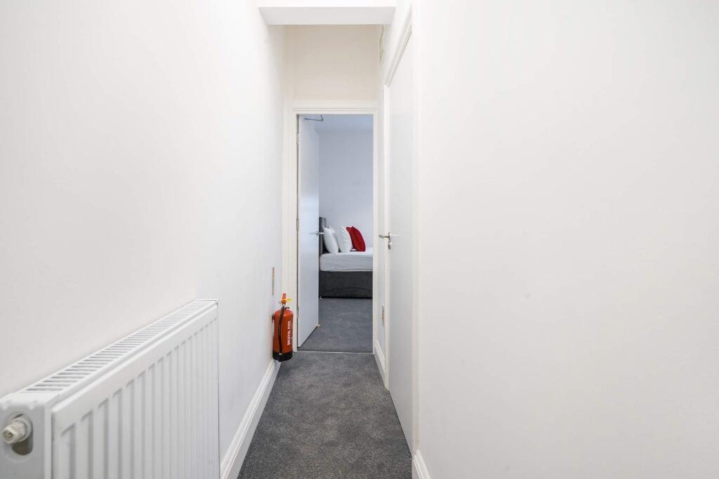 A bright and tidy hallway leading to inviting l...
